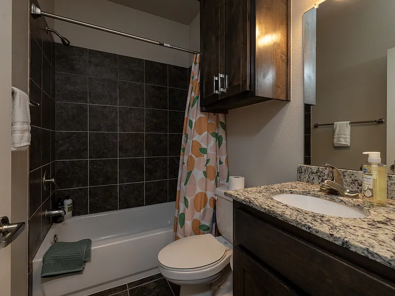 Bathroom 2 is located upstairs, it has a tub/shower combo with granite cabinet sink and mirror.