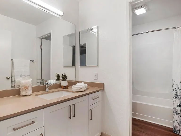 Baths with beige quartz countertops and white cabinetry