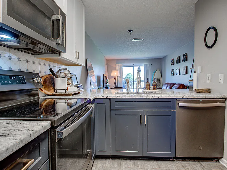 Kitchen view open to living room, with dishwasher