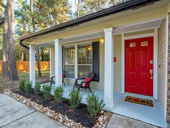 Gorgeous entry with covered front porch and stunning red door. A great place to welcome guests!