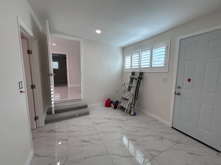 View from wash room: Back entrance (right), Kitchen area (center), bedroom 4 (left)