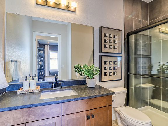 Enhance your secondary bathroom with vanity lighting and stylish tile accents.