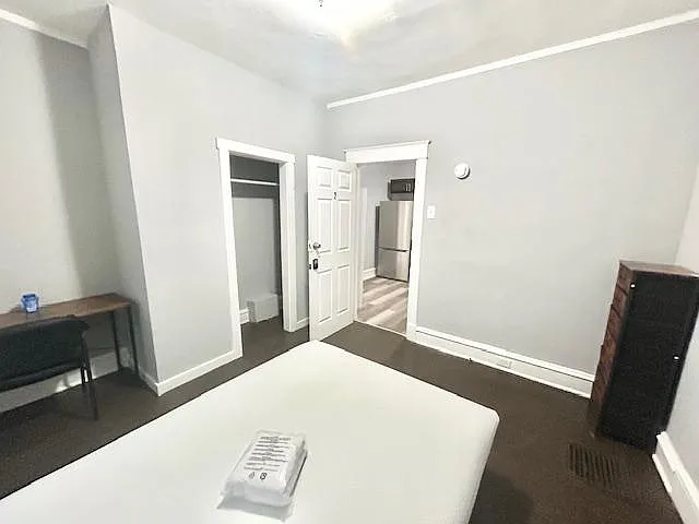 Bedroom offers a comfortable layout with tall ceilings, neutral finishes, and a dedicated closet plus space for a desk.