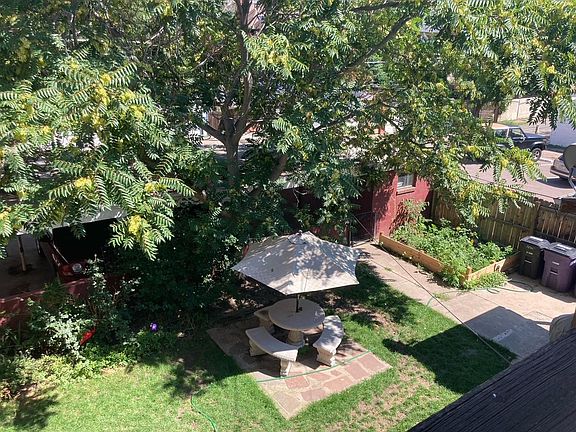 Fenced shared backyard with perennial flowers and grass. Included private parking shown from your private deck