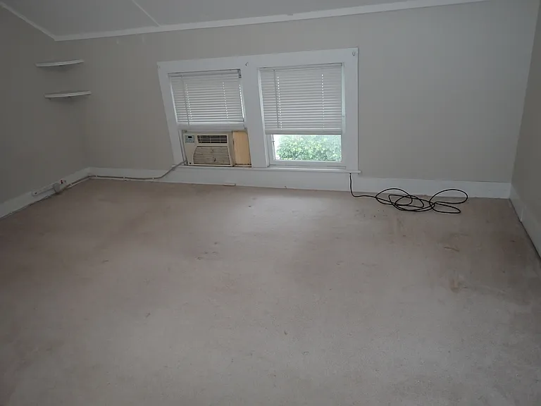 bedroom...off white carpeting...air conditioner included in rental. There is a very large walk-in closet. There is a very large storage area off bedroom.