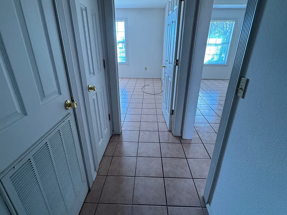 Hallway from bathroom to bedroom with closet space in the middle.