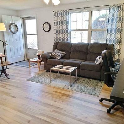Large living room with plenty of light, and recently refinished hardwood floors