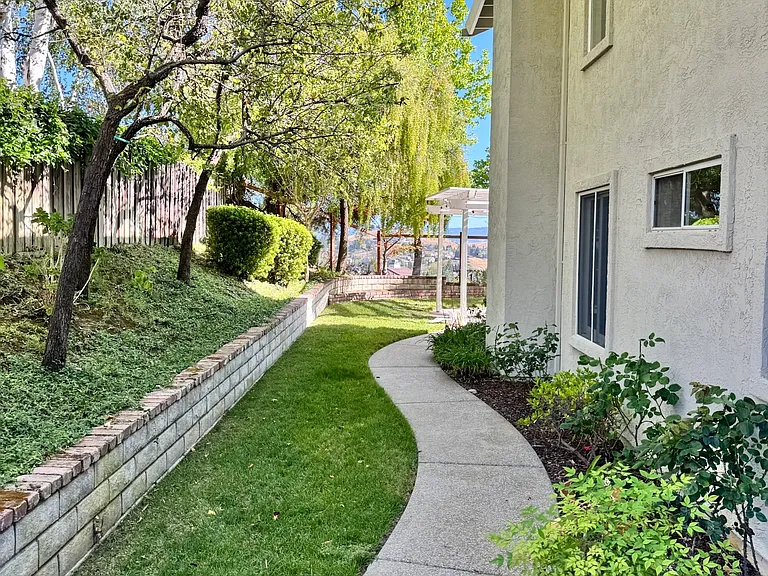 Landscaped side corridor with beautiful rose garden and cherry blossom trees