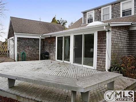 View of deck and attached single car garage garage in the back of the property.