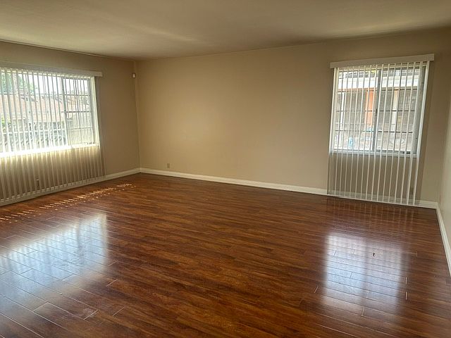 The spacious living room with great natural lighting and well-kept vinyl floors.