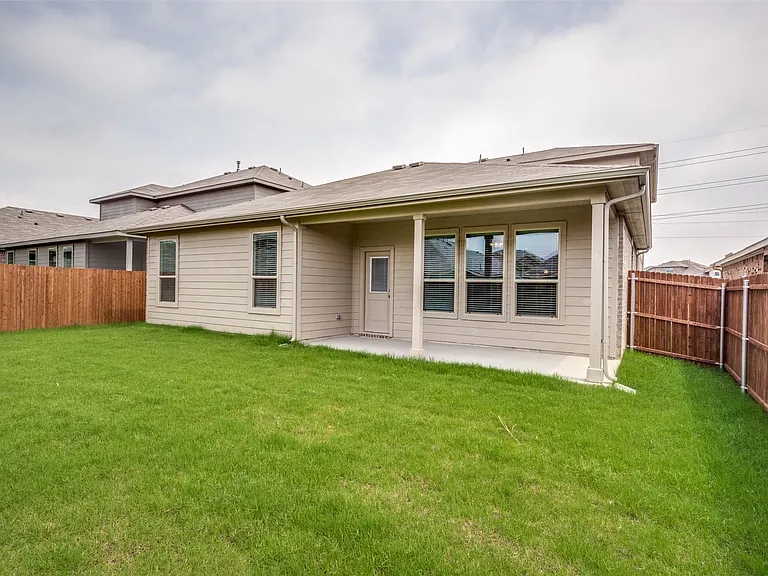 Rear view of house featuring a patio area and a lawn