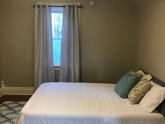 Bedroom off of living room with beautiful hardwood floors and 2 windows allowing plenty of natural light. Queen bed shown in photos.