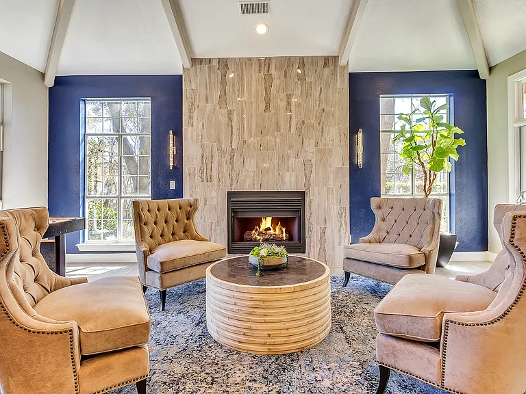 Resident lounge with plush seating, natural lighting and fireplace