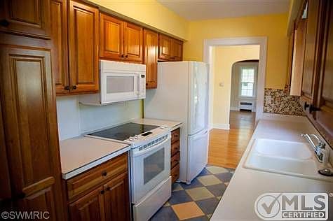 Galley style kitchen with ceramic tile and hardwood cabinets