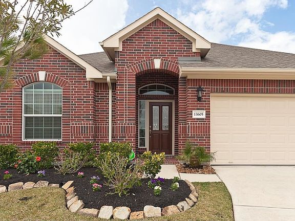 A view of the front covered porch and professional landscaping.