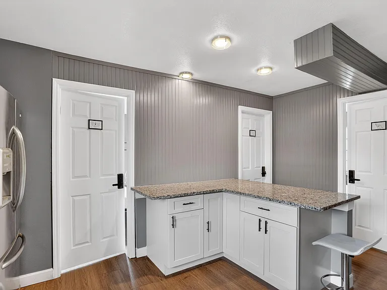 Updated kitchen with granite-look counters, ample cabinetry, and stainless refrigerator, plus a handy breakfast bar.