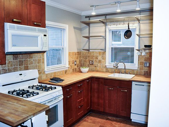 Kitchen, with gas stove, hood microwave, dishwasher, and open shelving