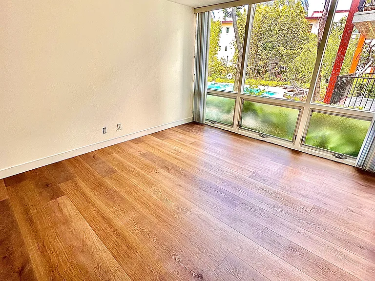 Unit #115 similar spacious primary bedroom overlooking the pool and gardens!