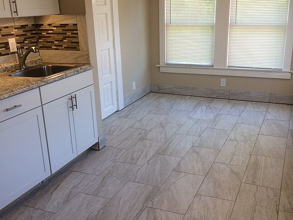 Kitchen widows overlook backyard and parking. Back door shown her exits onto a back deck overlooking backyard.