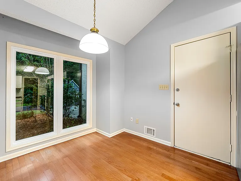 Breakfast nook in the kitchen. Door towards the garage. Large window replaced in 2022, with the front yard view