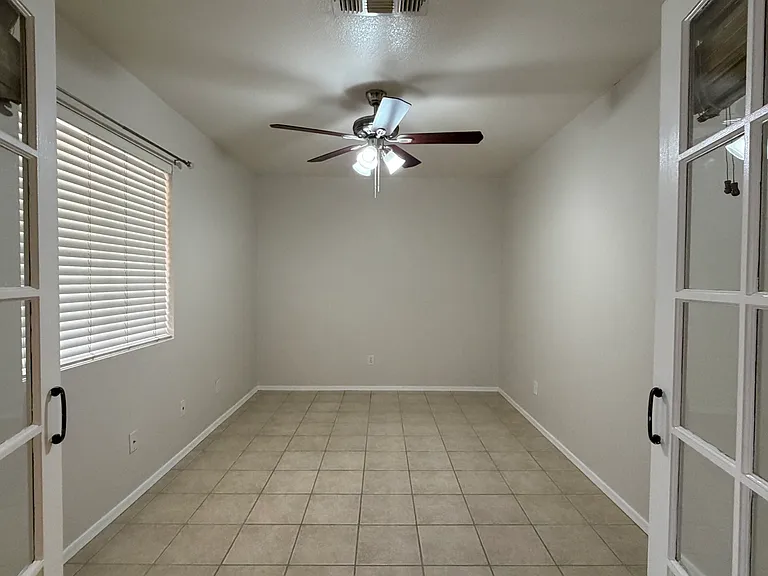 Den with French doors, tile floor & ceiling fan