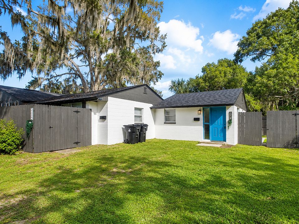 Exterior view of the property with mature oak trees.
