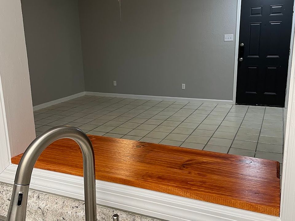 Window with bar between kitchen and living room keeps families connected.