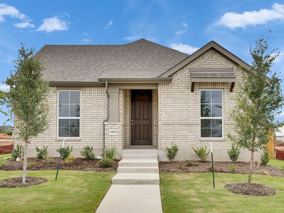 This Briarwood estate boasts a striking brick facade, arched doorway, and premium wooden shutters fo