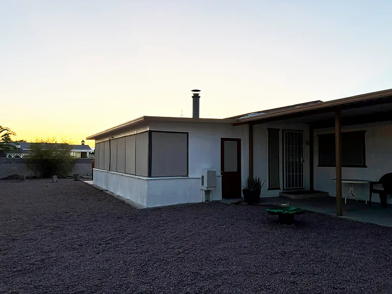 View of yard towards the front door and the sunroom which can be entered from the living room or outside.