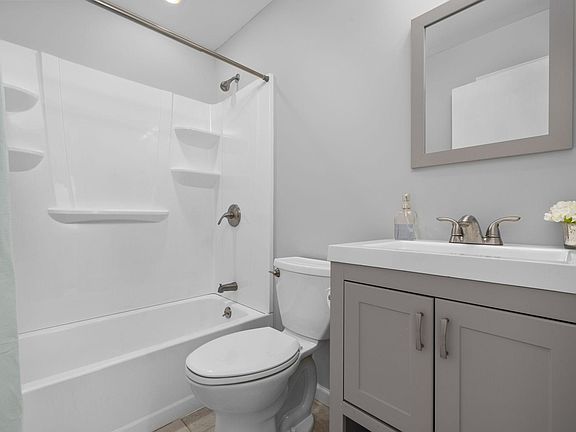 Updated bath with ceramic tile, stylish vanity, shower-tub and linen closet