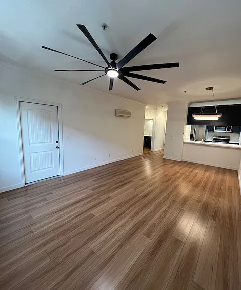 View from the front windows back into the condo to the brand new kitchen with eat at counter. and big ass fan. Unit also has two mini spolit air condtitioing units one in living area and another in the bedroom . Outdoor private balcony to the left