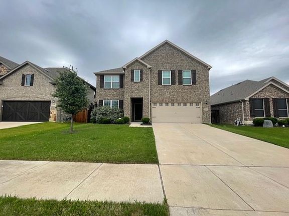 View of front of property with driveway, a front lawn, and a garage
