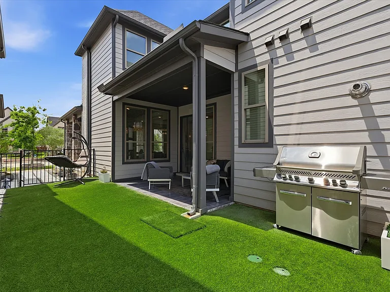 Covered patio with tile flooring and recessed lighting, overlooking the backyard and offering a peaceful outdoor view.
