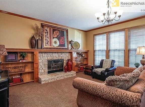 Great Room Opens to Kitchen w/Stone Fireplace & Wall of Windows