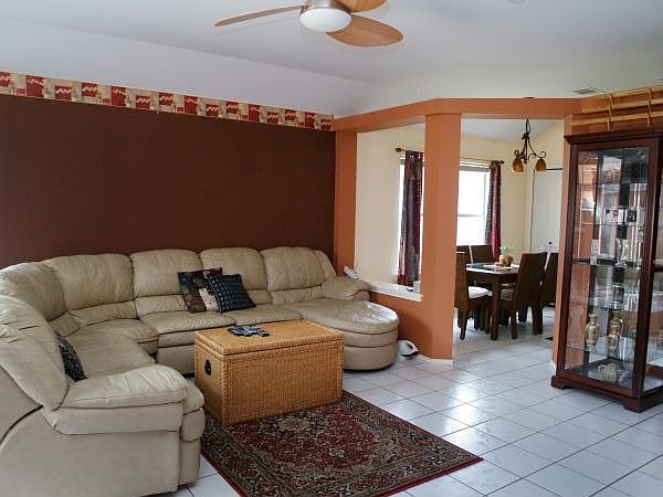 Living room with tile flooring and fireplace gets plenty of natural light.