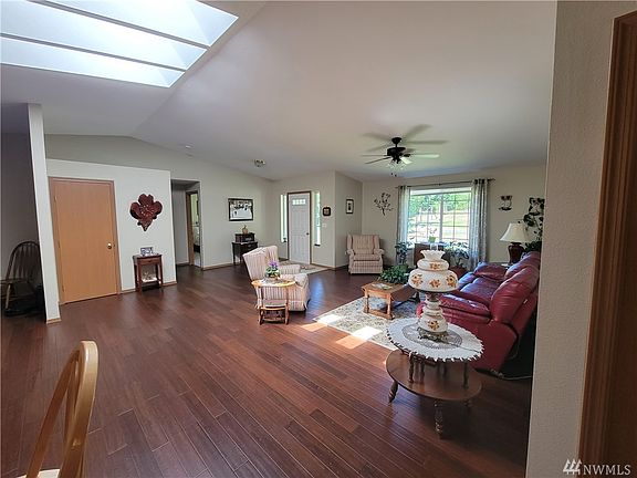 The large open concept living room has large windows and skylights filling the entire area with natural light.