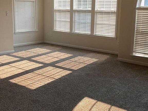 Extra large living room with beautiful windows and natural light.