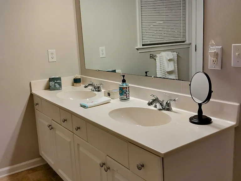 The primary bathroom features two sinks, a closet, and a separate linen closet.