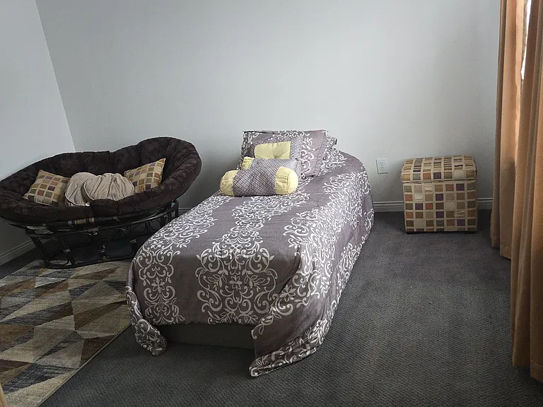 Bedroom 2: Twin bed, dresser, walk-in closet, area rug, remote-controlled ceiling fan, curtains, chair
