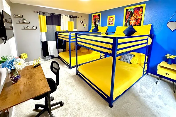 Showcasing the other side of the bedroom, which includes two bunk beds and a large window that allows plenty of natural light to fill the space.