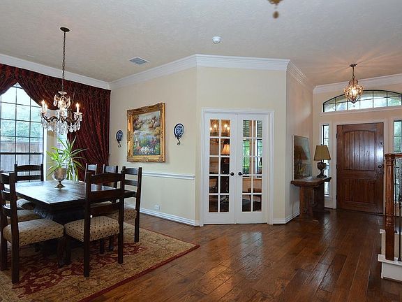 Stepping back a little further, the dining room with multi-paned windows overlooking side of the hou