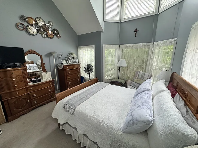 Primary bedroom with vaulted ceiling and lots of windows.