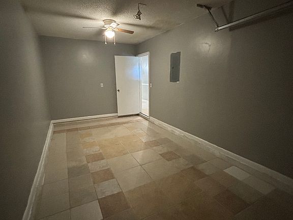 One car garage equipped with a ceiling fan and lighting