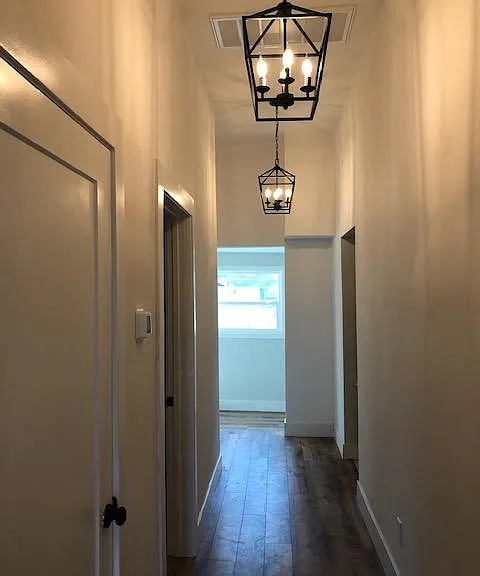 Spacious hallway with hall closet, beautiful LED lighting, natural light from the sunroom.