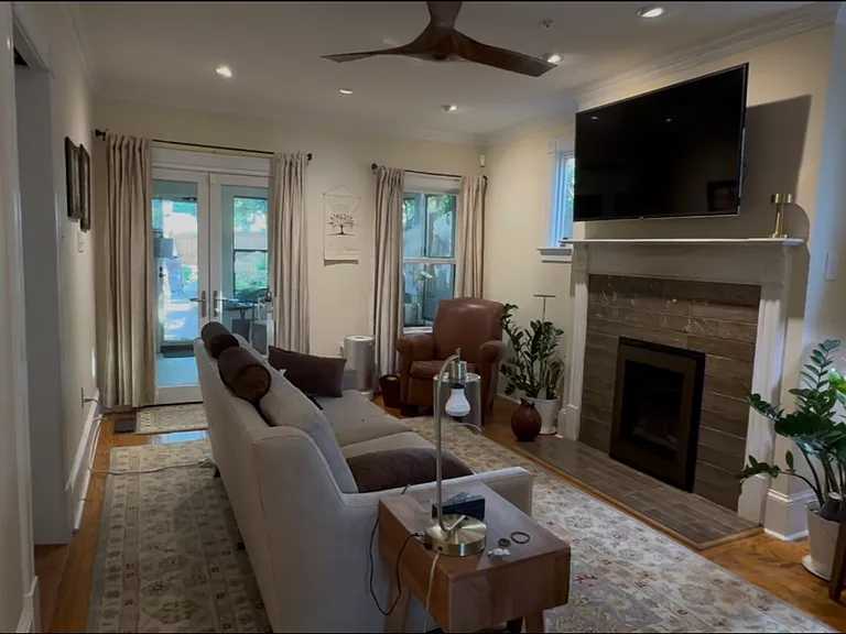 Family room w/ gas fireplace. French doors go to sunroom. TV on mount that pulls down to eye level.