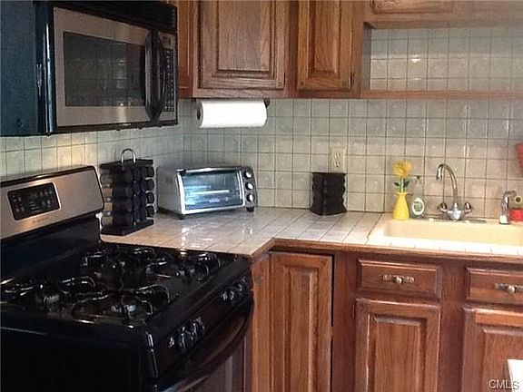 Wonderful kitchen with gas range, microwave, ceramic tlle counter and backsplash.