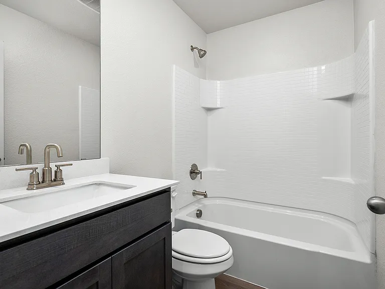 The secondary bathroom has a great vanity space and shower-tub combo.