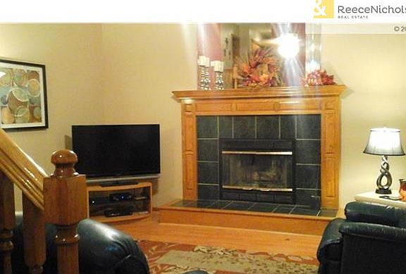 Wood burning fireplace and hardwood floors in living room.