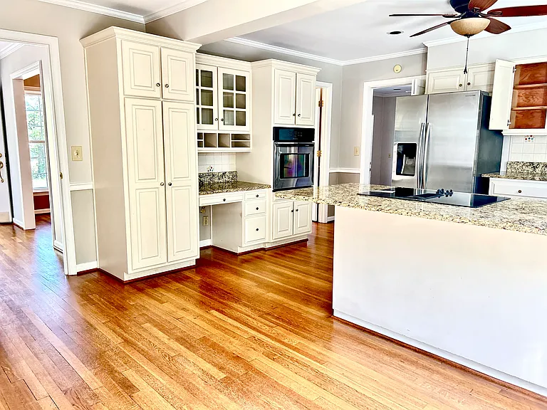 A large and bright kitchen with granite counter top, steel stainless appliances and plenty of kitchen cabinets. The view to the backyard, access to the living room, dining room, seperate laundry room and the basement door.