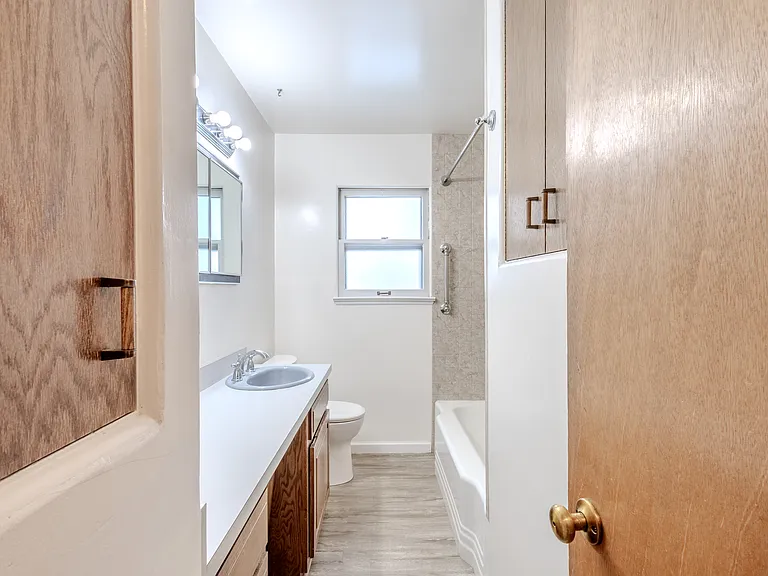 Large main bath with tons of built in cabinets, easy maintenance shower surround, deep tub, frosted privacy window.